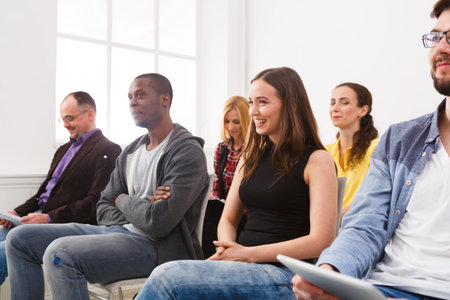 Group of People Attending a Workshop in a Bright Room With Large Windows