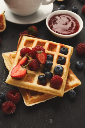 Delicious Waffle Collection With Fresh Fruits and Jam Served on a Dark Surface