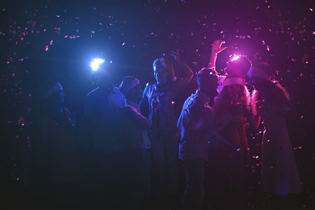 Group of Friends Celebrate With Colorful Lights and Confetti at a Lively Gathering