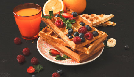 Waffles Served With Fresh Fruit and Orange Juice in a Bright Setting During Breakfast