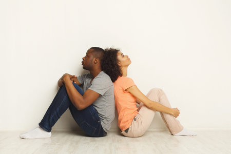 Couple Sitting Back to Back in a Modern Setting Expressing Emotional Distance and Tension