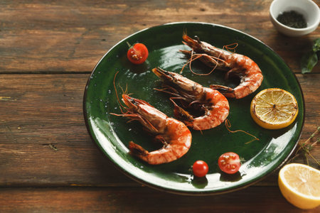 Collection of Shrimp With Lemon and Tomatoes on a Green Plate