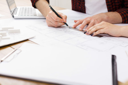 Planning a Construction Project at a Workspace With Design Documents and Tools on the Table