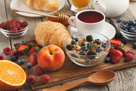Collection of Breakfast Foods on Wooden Table With Fruits, Cereals, and Tea on Display