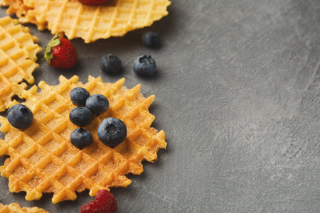 Waffle Collection With Berries Arranged on a Gray Surface During Morning Meal Preparation