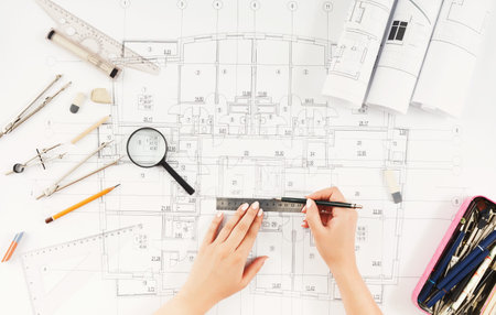 Sketching Floor Plans on Architectural Design Drawings in a Workspace With Tools and Materials