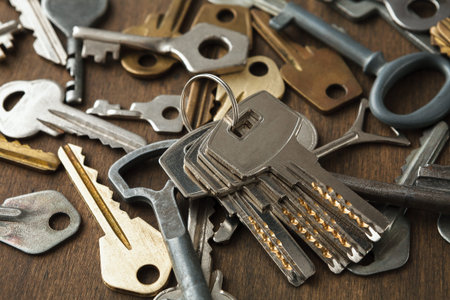 Collection of Metal Keys on a Wooden Table in a Casual Setting During Daylight Hours