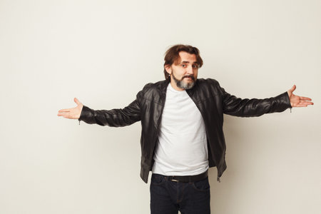 Man Gestures With Open Arms in a Simple Setting During a Casual Momentの写真素材