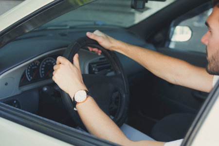 Driving Hands on a Steering Wheel in a Car Interior in Motion During a Daytime Journey