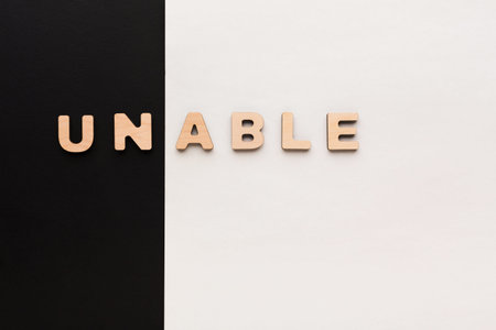 Wooden Letters Spelling Unable on Black and White Background During Dayの写真素材