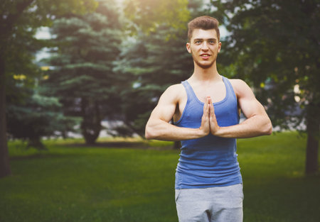 Young Man Practicing Yoga in a Park During the Dayの写真素材