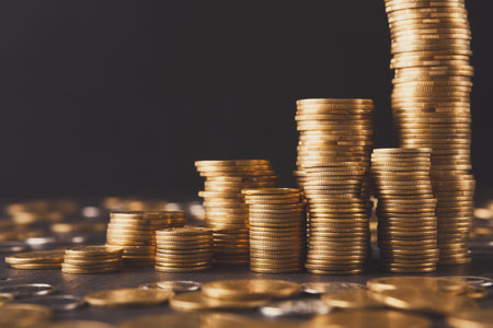 Collection of Gold Coins Arranged in Different Stacks on a Dark Surface