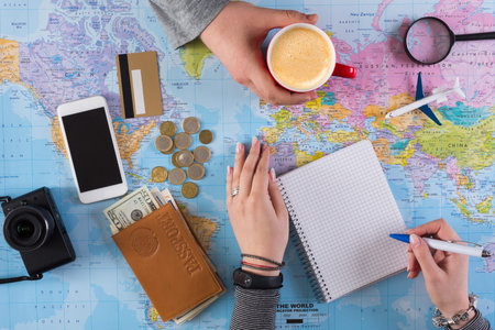 Planning a Trip With Maps, Notes, and Coffee in a Busy Workspace