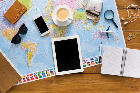 Exploring Plans and Travel Ideas With Maps, Devices, and Tools on a Wooden Table