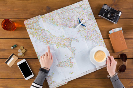 Planning a Trip With a Map, Coffee, and Travel Essentials on a Wooden Table