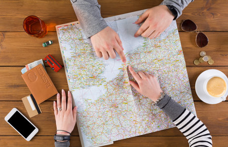 Planning a Road Trip With a Detailed Map and Personal Items on a Wooden Table