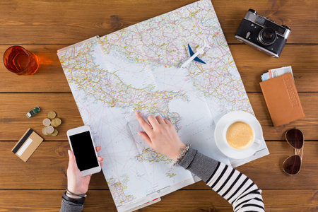 Planning a Trip With a Map, Phone, Coffee, and Wallet on a Wooden Table