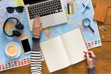 Planning a Trip With a Laptop and Map on a Wooden Table in the Morning