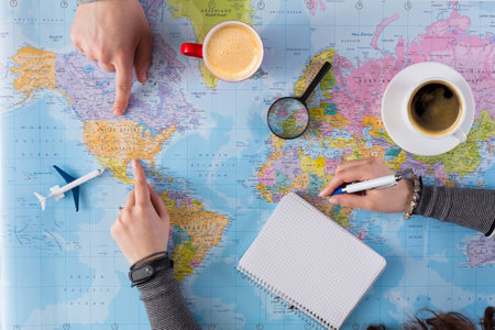 Planning a Travel Route on a World Map With Coffee and a Notebook in a Cozy Setting