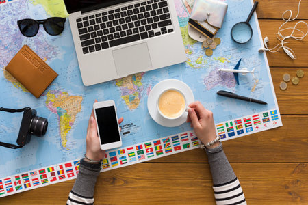 Planning a Trip With a Laptop, Smartphone, Coffee, and Map on a Wooden Table