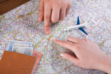 Planning a Trip Using a Map, Currency, and a Toy Airplane at a Table