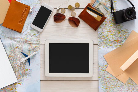 Travel Planning Setup With Tablet, Maps, and Essentials on a Table for Upcoming Trip