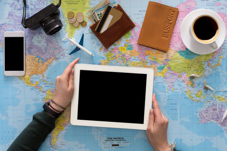 Planning a Trip With a Tablet, Map, and Travel Essentials on a Table