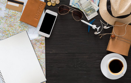 Planning a Trip With Travel Essentials on a Wooden Table