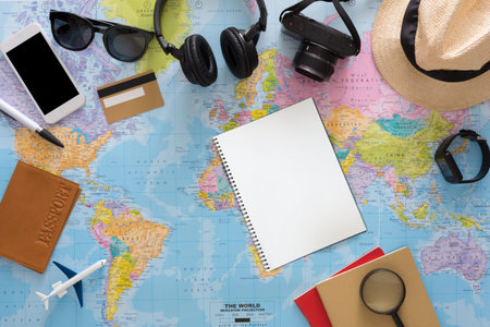 Travel Planning Tools and Items on a World Map With Empty Notebook and Camera Sitting Nearby