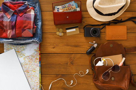 Travel Essentials Laid out on a Wooden Table for a Journey Planning Session During the Day