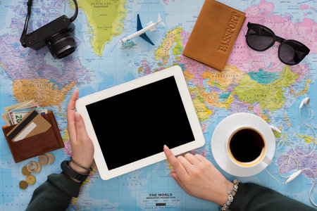 Planning a Trip With a Tablet and Travel Items on a World Map