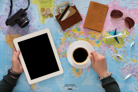 Planning a Trip With a Map, Tablet, Coffee, and Travel Essentials on a Table