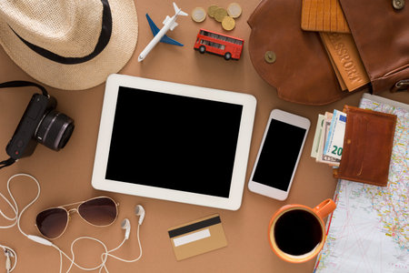 Travel Preparation With Electronic Devices and Travel Essentials on a Tableの写真素材