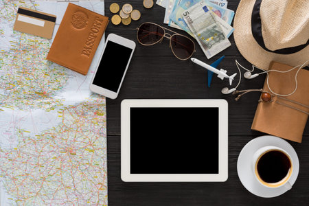 Planning a Trip With a Map, Travel Items, and Personal Belongings on a Table