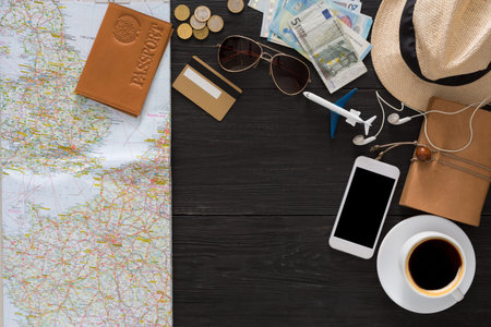 Travel Planning Includes a Map, Passport, Money, Phone, and Coffee on a Wooden Table