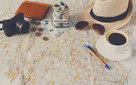 Planning a Travel Adventure With Map, Coffee, Cash, and Travel Gear on a Table