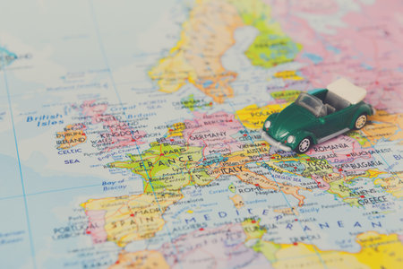 Model Car on a Map of Europe With Several Highlighted Countries and Cities
