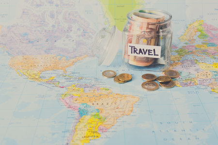 Saving Money for Travel With a Jar on a World Map Representing Future Adventures