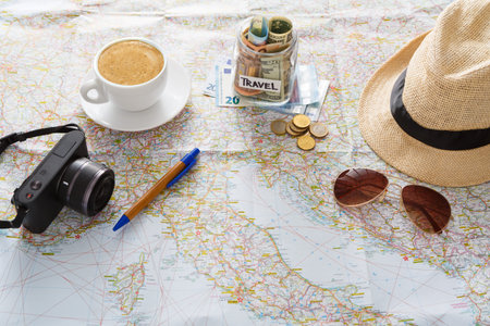 Planning a Trip With Coffee, Camera, and Travel Funds on a Map During the Day