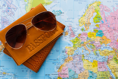 Travel Essentials on a Map of Europe With a Passport and Sunglasses Displayed
