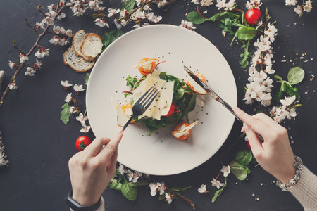 Fresh Salad Served on a Plate With People Preparing to Eat at a Table With Flowers