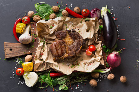 Grilled Meat With Vegetables Arranged on a Wooden Board in a Kitchen Settingの写真素材