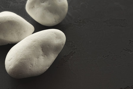 White Stones on a Dark Surface Showing Natural Textures and Shapesの写真素材