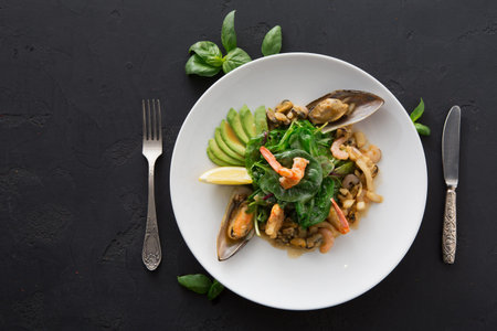 Seafood Dish With Shrimp, Mussels, and Greens Served on a White Plate With Garnishes
