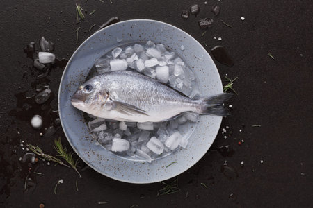 Fresh Fish on Ice Ready for Cooking in a Kitchen Setting With Herbs and Seasoning Nearby