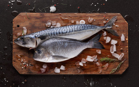 Fresh Fish on Wooden Cutting Board With Ice and Herbs at Kitchen Counter