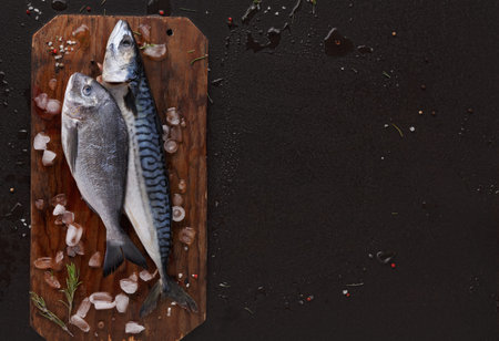 Fresh Fish on a Wooden Board Prepared for Cooking at a Kitchen Countertopの写真素材