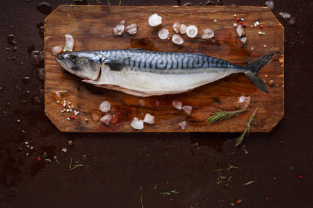 Fish Preparation on a Cutting Board With Salt and Spices in a Kitchen Settingの写真素材