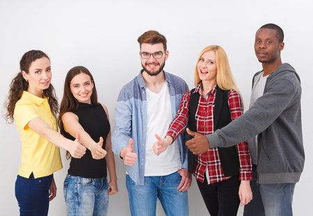 Group of Five Friends Showing Thumbs up in a Casual Setting at Indoor Location