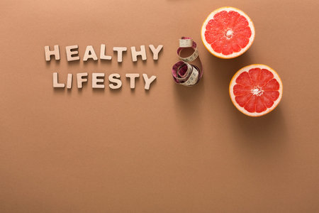 Enjoying Healthy Lifestyle Choices With Fruits and Measurement Tools on a Simple Backgroundの写真素材